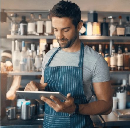 Barista consultă datele espressorului din spatele barului